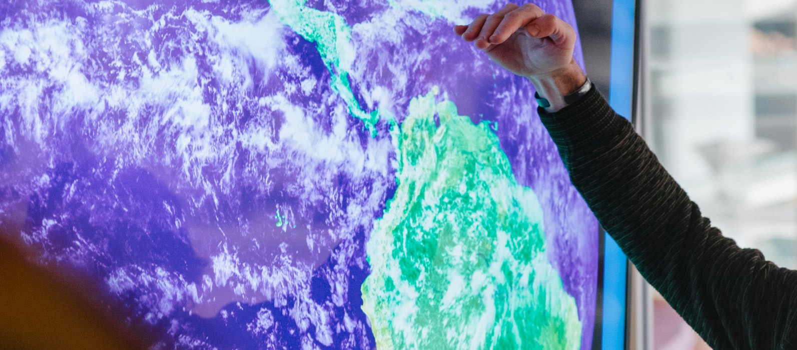 Student giving presentation using map showing cloud cover