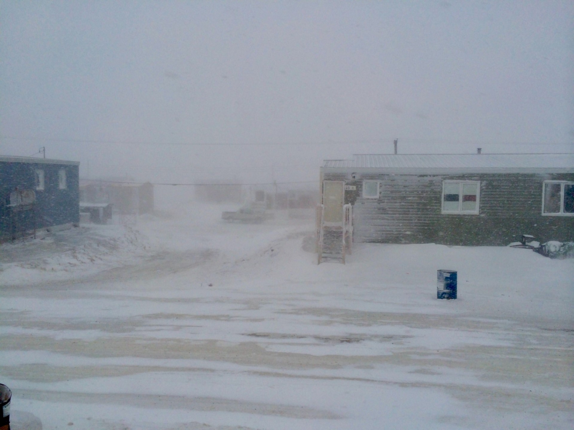 Single story houses in a blizzardy snowy landscape in Nunavut, Canada
